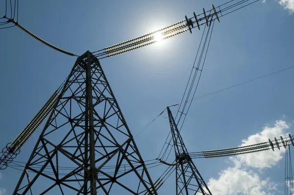 Pylons de linha de alta tensão de energia contra fundo céu azul — Fotografia de Stock