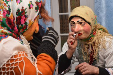 Vashkivtsi, Chernivtsi Oblastı, Ukrayna - 14.01.2013: Malanka Karnavalı - iki mummer sigara molası verdi.
