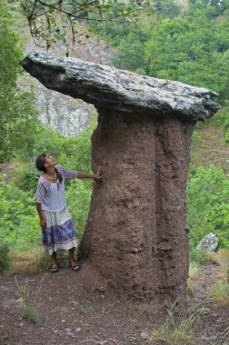 Woman looks at nature wonder - stone mushroom clipart