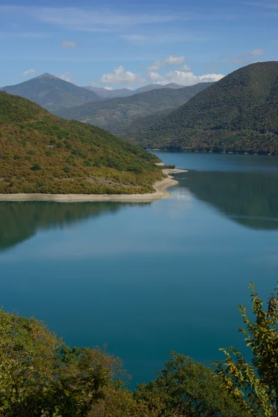 Lac azur entouré de montagnes verdoyantes — Photo