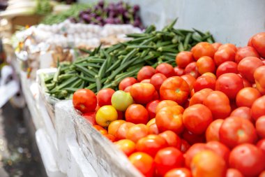 Pazarda bir grup taze domates ve organik sebze.