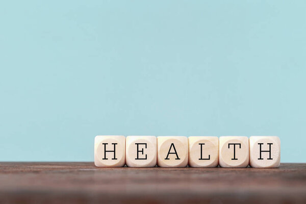 Здоровье слово написано в деревянном кубе на деревянном столе, здравоохранение и медицинское страхование концепции