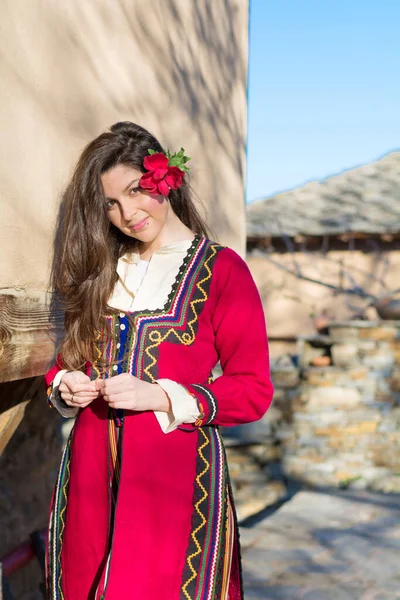 Bulgarian Girl Dressed in Traditional Dress . Typical Ethnic Bulgarian Red Costume with Colorful Ornaments
