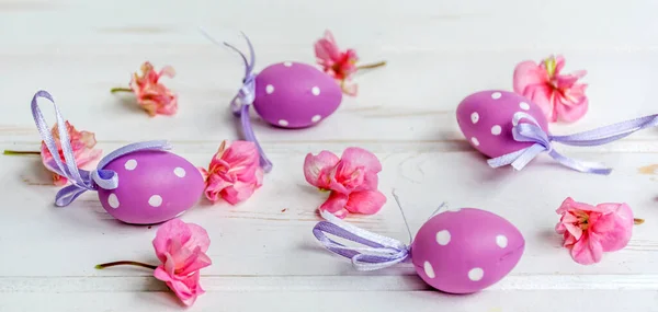 Пурпурные Пасхальные Яйца Белыми Точками Розовыми Цветами Белом Деревянном Фоне — стоковое фото