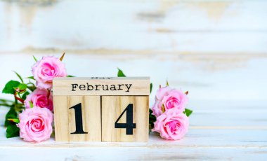 Tahta Takvim ve Beyaz Ahşap Arkaplanda Pembe Güllerle Sevgililer Günü Kartınız kutlu olsun.  