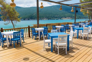 Mavi Sandalyeler, Masalar ve Deniz Manzaralı Açık Yunan Restoranı