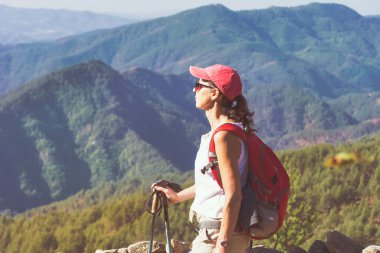 Bir dağın tepesinde sırt çantalı, çarpıcı manzaralı bir yürüyüşçü kadın. Pirin Dağı, Bulgaristan