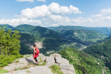 Yaz Dağı 'nın tepesinde sırt çantalı, çarpıcı manzaralı bir turist kadın. Bulgaristan 'da Yaz Dağı, Bov Köyü, Balkan Dağı, Iskar Boğazı