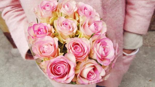 Woman with Pink Coat Holding Beautiful Bouquet of Pink Roses