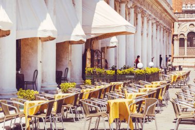 VENICE, İtalya, 10 Haziran 2018: San Marco Meydanı 'ndaki Kafe ve Restoran, Sarı Boş Sandalyeler ve Masalar