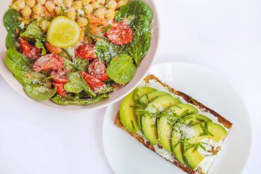 Avokado sandviçi ve kiraz domatesli salata, nohut ve bebek ıspanağı. Sağlıklı yiyecek.