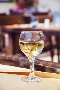 Restoran masasında bir bardak beyaz şarap.