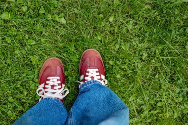 MILAN, ITALY - 24 Ağustos 2025: Kahverengi Adidas Samba 'lı bacaklar yeşil çimlerde