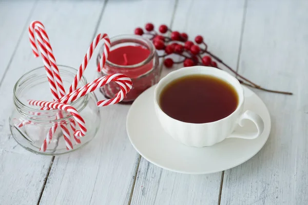 Tee Kerzen Weihnachtsstöcke Und Beeren Auf Weißem Holzgrund Selektiver Fokus — Stockfoto