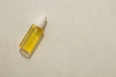 Güneş ışınlarındaki kozmetik yağları serumu ışık desenli bir arka planda. Düzen, düzlük, kopyalama alanı, üst görünüm. Model ve projeniz için minimalist konsept.