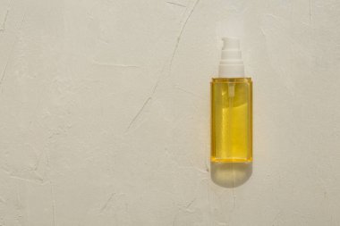 Güneş ışınlarındaki kozmetik yağları serumu ışık desenli bir arka planda. Düzen, düzlük, kopyalama alanı, üst görünüm. Model ve projeniz için minimalist konsept.