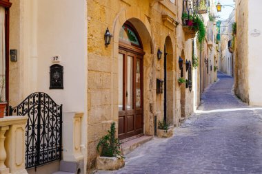 Victoria (Rabat), Malta - 9 Mart 2017: Geleneksel kireçtaşı evleriyle antik Rabat kentinin dar sokakları