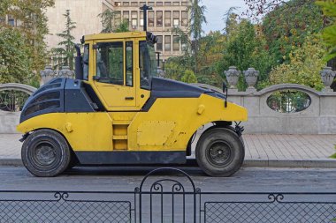 Sokak inşaatında büyük sarı yol silindiri.