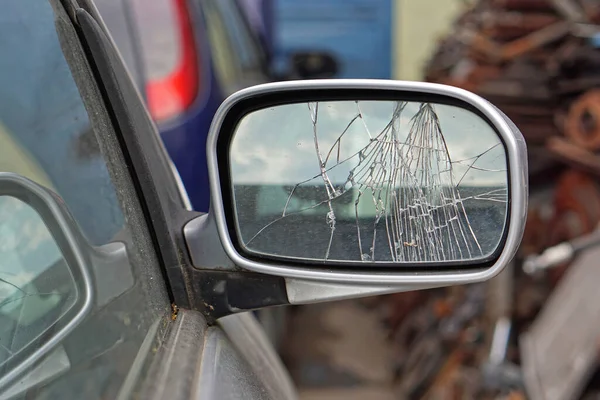 Arabanın yan aynasında kırık camlar hasar görmüş.