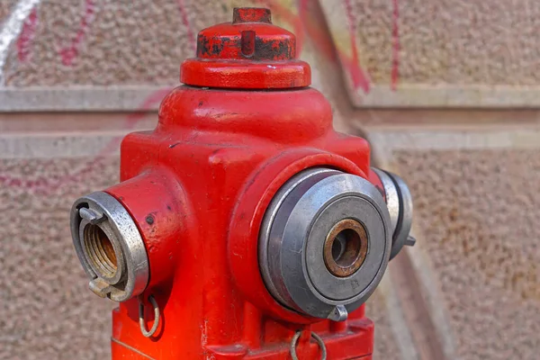 Red fire hydrant with water valves close up