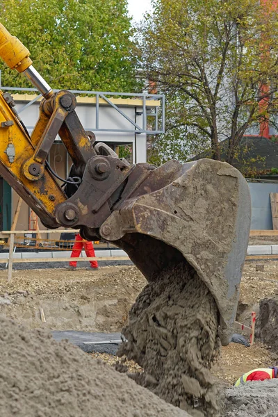 Kazıcı inşaat alanında kum boşaltıyor.