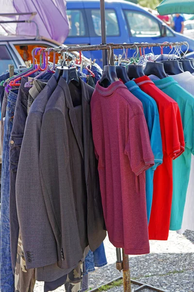 Suits shirts and pants hanging at clothes rails flea market
