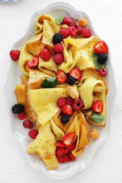 Crepes con bacche fresche su piatto bianco — Foto Stock