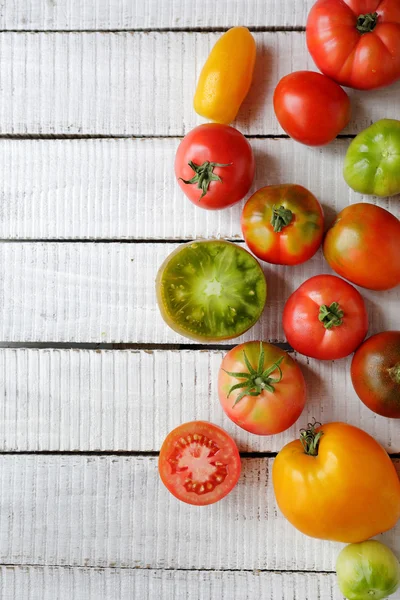 Verse tomaten op witte planken — Stockfoto