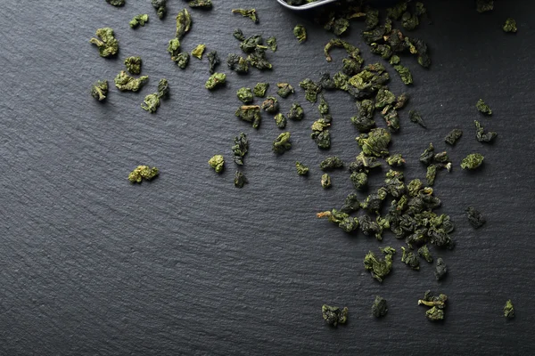 Chinese green tea leaves on slate — Stock Photo, Image