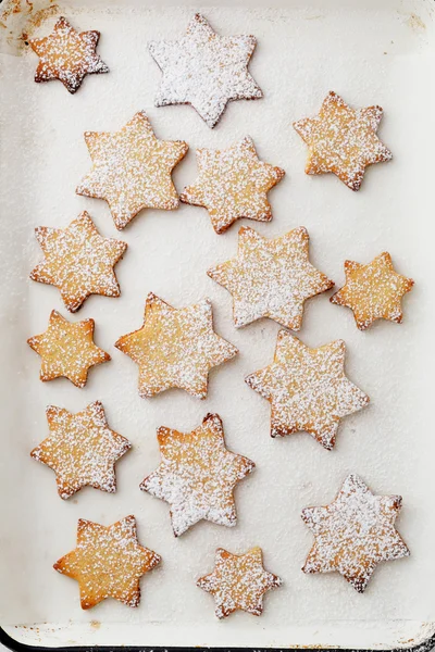 Τα cookies αστέρια σε λευκό χαρτί ψησίματος — Φωτογραφία Αρχείου