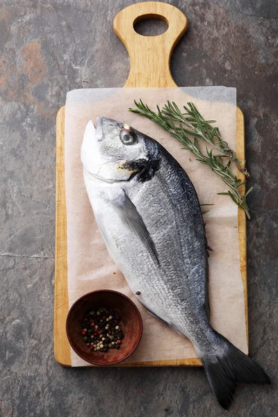 Ruwe dorada vis op snijplank — Stockfoto