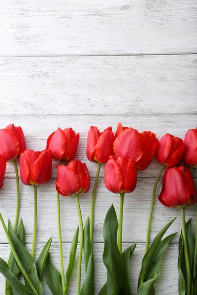 Rote Tulpen auf hölzernem Hintergrund — Stockfoto