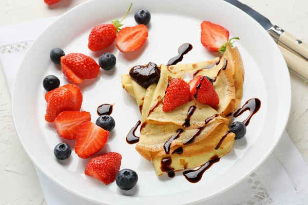 Hot crepes with berries and chocolate — Stock Photo, Image