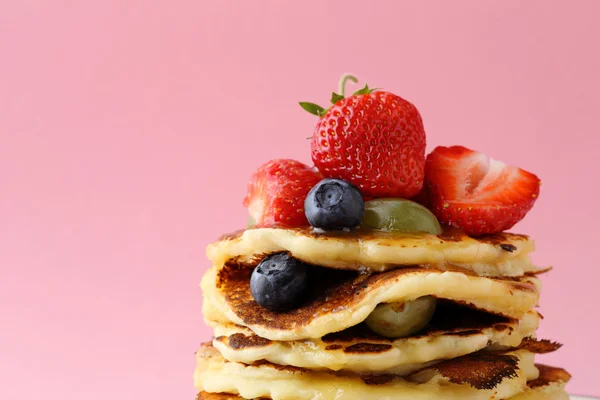 Pannkakor med bär mot rosa bakgrund — Stockfoto