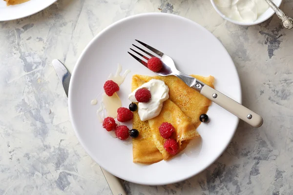 Gouden crêpe met frambozen en crème — Stockfoto