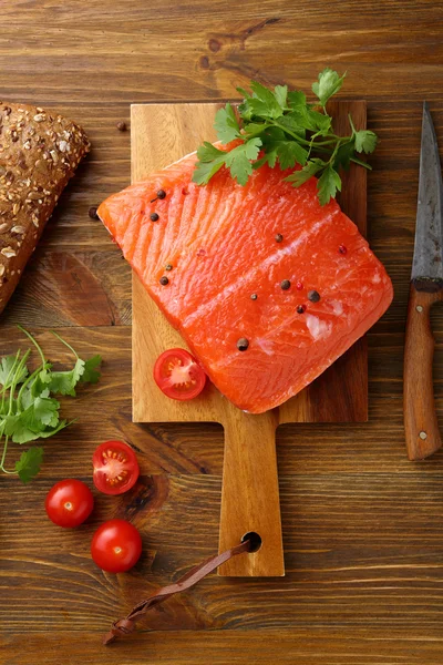 Filete de salmón crudo en tabla de cortar — Foto de Stock