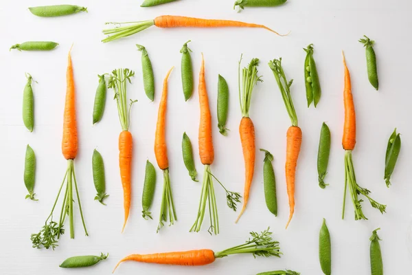 Rauwe wortelen en groene erwten patroon — Stockfoto