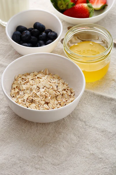 Breakfast ingredients in bowls with honey — Stock Photo, Image