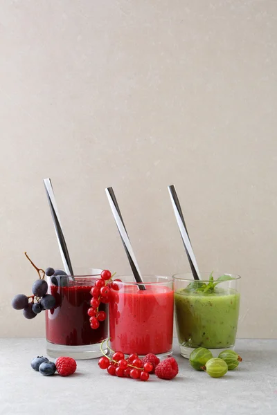 Ассортимент фруктовых коктейлей в стакане с соломинками на белом набережной — стоковое фото