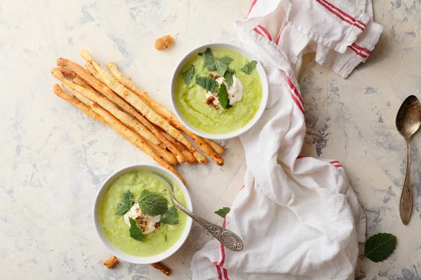 Bowls of broccoli cream soup and bread sticks — Stock Photo, Image