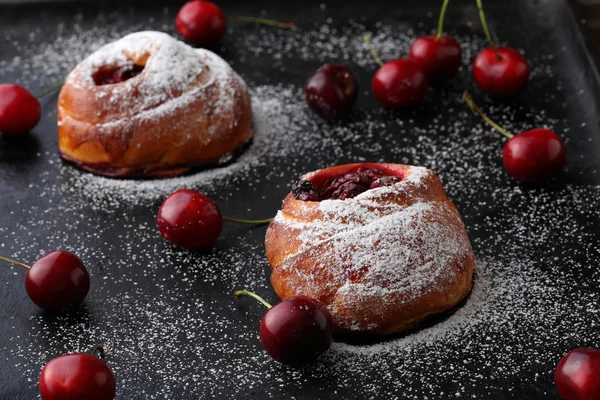 Homemade buns with cherry on black background — Stock Photo, Image