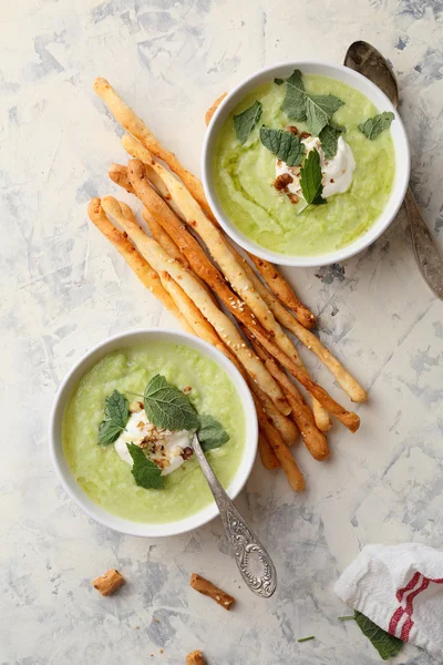 Two bowls of Green summer soup with grissini — Stock Photo, Image