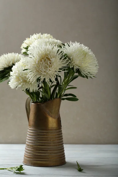 Bílé květy v džbánu na dřevo stůl — Stock fotografie