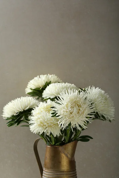 Flowers in bronze pitcher — Stock Photo, Image