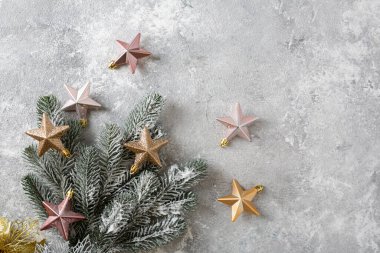 Altın Noel süslerinin, yıldızların ve yeşil karlı dalların manzarası. Tatil kavramı