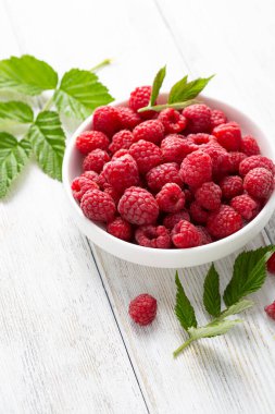 Ahududu kasesini beyaz ahşap masaya koy.