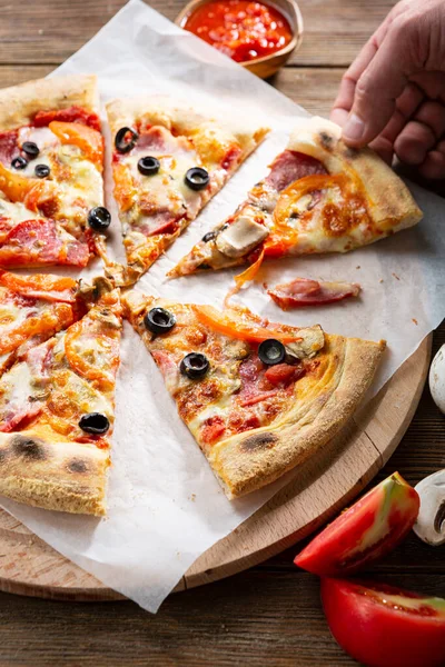 Close Van Gesneden Pizza Snijplank Hand Trek Een Plakje — Stockfoto