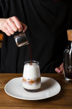 Barista buzlu kahve yapıyor, yüzü yok.