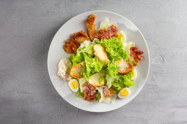 Açık gri yüzeye yakın tavuk sezar salatası.
