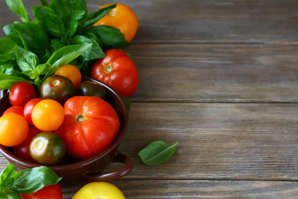 Houten achtergrond met tomaten en basilicum — Stockfoto